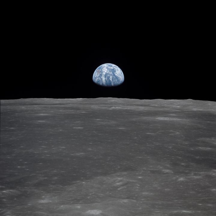 View of Earth in space from the moon, where the bottom half of the photo is the moon's surface.