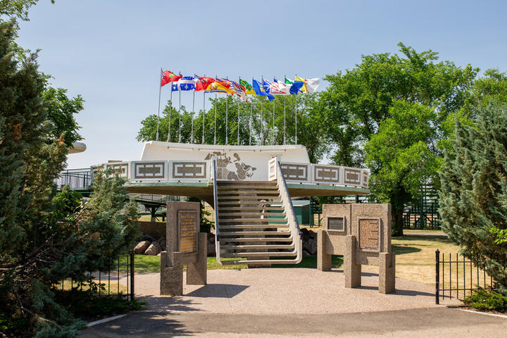 UFO landing pad with flags perched on top and surrounded by trees.
