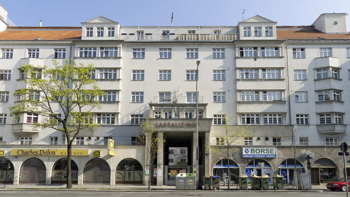 Large white housing complex above commercial space in Germany.