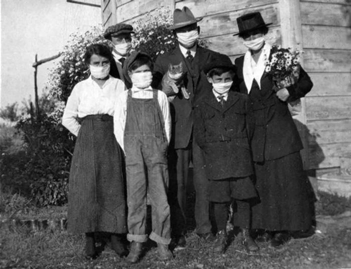 An American family, wearing masks, and their cat during the 1918 Spanish flu epidemic.