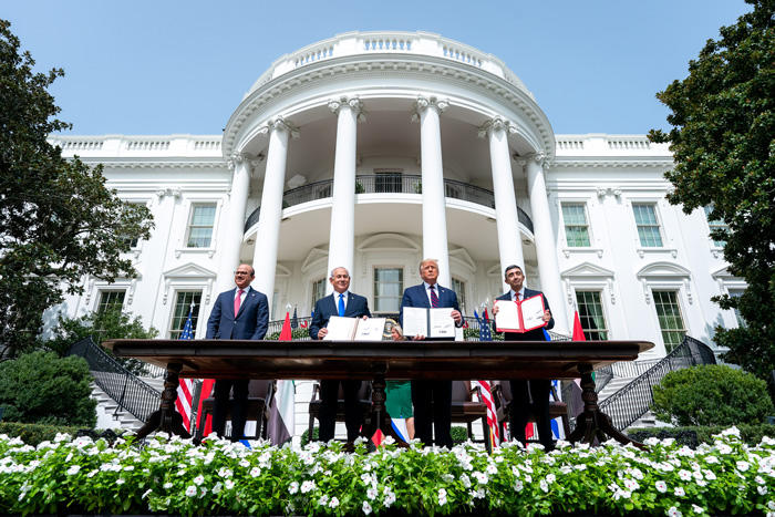 Four men stand in front of the White House signing the Abraham Accords: Donald Trump, Dr. Abdullatif bin Rashid Al-Zayani, Benjamin Netanyahu, and Abdullah bin Zayed Al Nahyani.