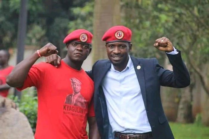Bobi Wine and his driver, Frank, pose for the camera with raised fists