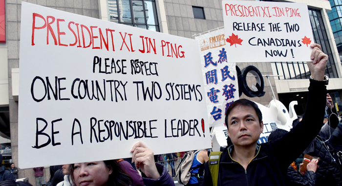 Hong Kong citizens at protest holding up signs to release Canadians in Chinese custody
