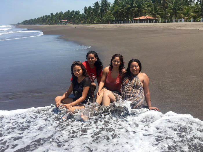 Image of four young women accused of homicide, sitting on the beach