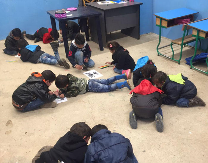 Image of students working on the floor on a group story creation