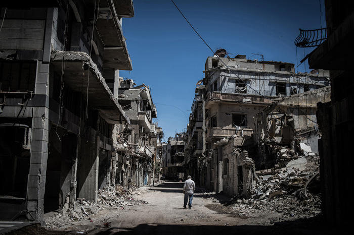 Image of Syrian refugee walking in downtown Homs, Syria